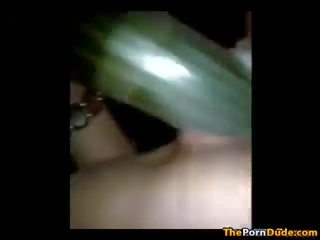 Meisje eikels haarzelf met een groot komkommer