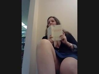 Hon filmer själv cumming i bibliotek